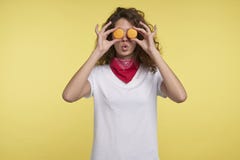 Смешная молодая женщина держа macaroons около глаз, против желтой предпосылки стоковые изображения Смешная молодая женщина держа macaroons около глаз, против желтой предпосылки стоковые изображения