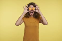 Смешная усмехаясь молодая женщина брюнета показывает macaroons перед глазами, изолированными над желтой предпосылкой стоковое изображение Смешная усмехаясь молодая женщина брюнета показывает macaroons перед глазами, изолированными над желтой предпосылкой стоковое изображение