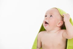 Смешной маленький младенец при зеленое полотенце смотря прочь на космосе экземпляра. стоковое фото Смешной маленький младенец при зеленое полотенце смотря прочь на космосе экземпляра. стоковое фото