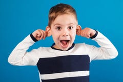 Смешной счастливый молодой мальчик в свитере показывая гримасу на камере стоковая фотография Смешной счастливый молодой мальчик в свитере показывая гримасу на камере стоковая фотография
