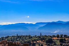 Смотрящ вне через полуостров Peloponnesus в южной Греции от руин старого Mycenae около сумрака с ветротурбинами VI стоковое фото Смотрящ вне через полуостров Peloponnesus в южной Греции от руин старого Mycenae около сумрака с ветротурбинами VI стоковое фото