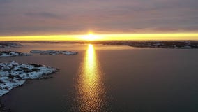Снег на побережье в заходе солнца Снег на побережье в заходе солнца