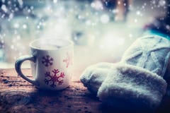 Снежинки Mug с горячим напитком и вязать mittens на силле окна заморозка на природе снега зимы Стоковые Изображения Снежинки Mug с горячим напитком и вязать mittens на силле окна заморозка на природе снега зимы Стоковые Изображения