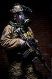 Солдат с винтовкой и респиратор на темной предпосылке стоковая фотография Солдат с винтовкой и респиратор на темной предпосылке стоковая фотография