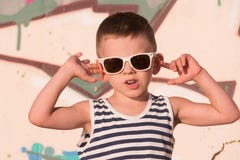 Солнечные очки холодного мальчика нося и striped жилет на предпосылке граффити стоковое изображение rf Солнечные очки холодного мальчика нося и striped жилет на предпосылке граффити стоковое изображение rf