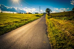 Солнце устанавливая над проселочной дорогой около перекрестных дорог, Pennsylvan Стоковые Фотографии RF Солнце устанавливая над проселочной дорогой около перекрестных дорог, Pennsylvan Стоковые Фотографии RF