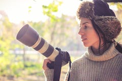 Современная камера с большим объективом в руке молодой девушки фотографа и готовый для того чтобы принять фото стоковое фото rf Современная камера с большим объективом в руке молодой девушки фотографа и готовый для того чтобы принять фото стоковое фото rf