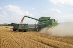 Современное вырезывание жатки зернокомбайна John Deere cts 9780i подрезывает ячмень пшеницы мозоли работая золотое поле стоковое изображение Современное вырезывание жатки зернокомбайна John Deere cts 9780i подрезывает ячмень пшеницы мозоли работая золотое поле стоковое изображение