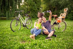 Соедините в любов принимая selfies со смартфоном в парке стоковые изображения rf Соедините в любов принимая selfies со смартфоном в парке стоковые изображения rf