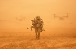 Солдат идя в пустыню с шестернями войны стоковое изображение rf Солдат идя в пустыню с шестернями войны стоковое изображение rf