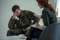 Солдат профессионального психиатра поддерживая плача с синдромом войны в офисе стоковые фотографии rf Солдат профессионального психиатра поддерживая плача с синдромом войны в офисе стоковые фотографии rf