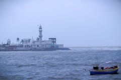 Сольная шлюпка в Аравийском море на Мумбай с хаджами Али Dargah на предпосылке стоковое изображение rf Сольная шлюпка в Аравийском море на Мумбай с хаджами Али Dargah на предпосылке стоковое изображение rf