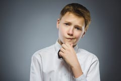 Сомнение, выражение и концепция людей - мальчик думая над серой предпосылкой стоковое фото Сомнение, выражение и концепция людей - мальчик думая над серой предпосылкой стоковое фото