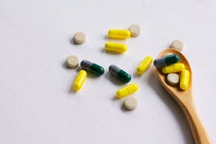Сортированные фармацевтические таблетки, планшеты и капсулы медицины на деревянной ложке стоковое изображение rf Сортированные фармацевтические таблетки, планшеты и капсулы медицины на деревянной ложке стоковое изображение rf