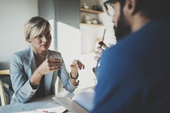 Сотрудники работая процесс дома Молодая белокурая женщина работая вместе с бородатым человеком коллеги на современном домашнем оф стоковое изображение rf Сотрудники работая процесс дома Молодая белокурая женщина работая вместе с бородатым человеком коллеги на современном домашнем оф стоковое изображение rf