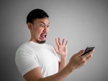 Сотрясенная и страшная сторона человека получает выкрикиванной от смартфона См. s стоковые фотографии rf Сотрясенная и страшная сторона человека получает выкрикиванной от смартфона См. s стоковые фотографии rf