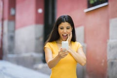Сотрясенная и удивленная привлекательная молодая латинская женщина отправляя СМС и говоря на ее умном сотовом телефоне стоковые изображения Сотрясенная и удивленная привлекательная молодая латинская женщина отправляя СМС и говоря на ее умном сотовом телефоне стоковые изображения
