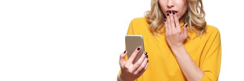 Сотрясенная молодая женщина задерживая ее мобильный телефон, читая сотрясая новости Женщина в неверии, изолированном над белизной стоковое фото Сотрясенная молодая женщина задерживая ее мобильный телефон, читая сотрясая новости Женщина в неверии, изолированном над белизной стоковое фото