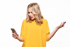 Сотрясенная сердитая молодая женщина смотря ее мобильный телефон в неверии Женщина вытаращить на shocking текстовом сообщении на стоковое изображение Сотрясенная сердитая молодая женщина смотря ее мобильный телефон в неверии Женщина вытаращить на shocking текстовом сообщении на стоковое изображение