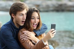Сотрясенные пары наблюдая умный телефон на праздниках Сотрясенные пары наблюдая умный телефон на праздниках