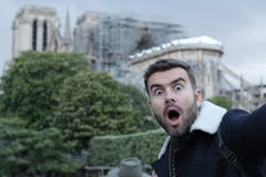 Сотрясенный человек наблюдающ реконструкцией Нотр-Дам стоковые фотографии rf Сотрясенный человек наблюдающ реконструкцией Нотр-Дам стоковые фотографии rf