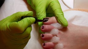 спа крупного плана 4k и концепция красоты Мастерский pedicure в зеленых перчатках прикладывая маникюр Профессиональная процедура сток-видео спа крупного плана 4k и концепция красоты Мастерский pedicure в зеленых перчатках прикладывая маникюр Профессиональная процедура сток-видео