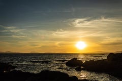 Спокойная вода во время захода солнца за островом стоковая фотография Спокойная вода во время захода солнца за островом стоковая фотография
