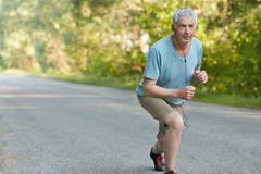 Спортсмен убежденный собственной личностью старший готовый для того чтобы начать jogging марафон, слушает музыка, который нужно р стоковые изображения Спортсмен убежденный собственной личностью старший готовый для того чтобы начать jogging марафон, слушает музыка, который нужно р стоковые изображения
