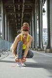 Спортсменка связывая шнурки на мосте Pont de Bir-Hakeim, Париже стоковое изображение rf Спортсменка связывая шнурки на мосте Pont de Bir-Hakeim, Париже стоковое изображение rf
