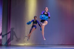 Спортсмены выполняют на этапе, молодые чирлидеры выполняют на чемпионате черлидинг, девушках в скачке, девушках держат помпоны стоковая фотография Спортсмены выполняют на этапе, молодые чирлидеры выполняют на чемпионате черлидинг, девушках в скачке, девушках держат помпоны стоковая фотография
