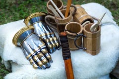 Средневековые перчатки руки металла рыцаря и деревянная чашка для питья на белом одеяле меха стоковое изображение Средневековые перчатки руки металла рыцаря и деревянная чашка для питья на белом одеяле меха стоковое изображение