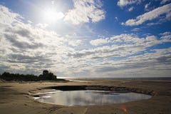 Среднего размера пляж лужицы воды стоковые фотографии rf Среднего размера пляж лужицы воды стоковые фотографии rf
