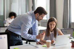 Средний достигший возраста ментор объясняя онлайн работу детенышам сфокусировал взаимо- стоковое фото rf Средний достигший возраста ментор объясняя онлайн работу детенышам сфокусировал взаимо- стоковое фото rf