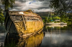 Старая покинутая шлюпка на струясь озере Лох-Несс в Шотландии Стоковая Фотография Старая покинутая шлюпка на струясь озере Лох-Несс в Шотландии Стоковая Фотография