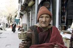 Старое буддийское колесо молитве монаха (лама) вращая на дороге в Ladakh, Индии стоковая фотография rf Старое буддийское колесо молитве монаха (лама) вращая на дороге в Ladakh, Индии стоковая фотография rf