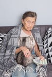 Старость темы, здравоохранение одиночества старая grayhaired кавказская женщина с глубокими морщинками сидя с котом домашнего жив стоковое изображение rf Старость темы, здравоохранение одиночества старая grayhaired кавказская женщина с глубокими морщинками сидя с котом домашнего жив стоковое изображение rf
