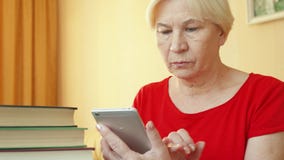 Старшая женщина используя применение для учить иностранные языки на smartphone, делая тренировку в-app акции видеоматериалы Старшая женщина используя применение для учить иностранные языки на smartphone, делая тренировку в-app акции видеоматериалы
