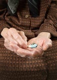 Старшее удерживание женщины сортировало капсулы в ее руках. стоковые изображения Старшее удерживание женщины сортировало капсулы в ее руках. стоковые изображения