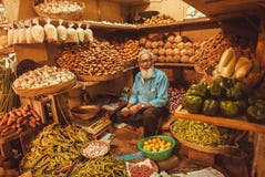 Старшие продавая плодоовощи, имбирь, кокосы и овощи для клиентов на рынке фермеров Стоковое Фото Старшие продавая плодоовощи, имбирь, кокосы и овощи для клиентов на рынке фермеров Стоковое Фото