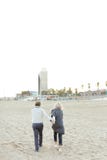 Старший супруг и жена бежать на пляже песка и держа руки стоковая фотография rf Старший супруг и жена бежать на пляже песка и держа руки стоковая фотография rf