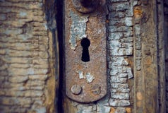Старый ржавый keyhole в старой деревянной двери стоковая фотография rf Старый ржавый keyhole в старой деревянной двери стоковая фотография rf