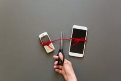Старый телефон и новый smartphone подключили красным ИМПом ульс кладя на серую бумажную предпосылку Ножницы отрезали поток Прекра Стоковые Фото Старый телефон и новый smartphone подключили красным ИМПом ульс кладя на серую бумажную предпосылку Ножницы отрезали поток Прекра Стоковые Фото