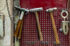 4 старых молотка с коричневой деревянной ручкой и вид струбцины на стене в мастерской для работы плотничества на красной предпосы стоковая фотография rf 4 старых молотка с коричневой деревянной ручкой и вид струбцины на стене в мастерской для работы плотничества на красной предпосы стоковая фотография rf