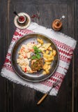 Стейки поясницы свинины с травами crust, картошки жаркого и соус сальсы в деревенской плите Стоковое Изображение Стейки поясницы свинины с травами crust, картошки жаркого и соус сальсы в деревенской плите Стоковое Изображение