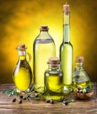 Стеклянные бутылки оливкового масла и немногих ягод на деревянном столе стоковые фото Стеклянные бутылки оливкового масла и немногих ягод на деревянном столе стоковые фото