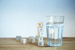 Стекло воды с деревянными блоками Стоковые Фотографии RF Стекло воды с деревянными блоками Стоковые Фотографии RF