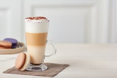 Стеклянный latte чашки кофе и красочные macaroons на деревянном столе стоковое изображение rf Стеклянный latte чашки кофе и красочные macaroons на деревянном столе стоковое изображение rf