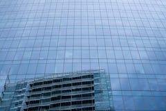 Стеклянный фасад башни Aldgate в главной улице Whitechapel, Лондоне, с отражением неба и здания напротив стоковая фотография Стеклянный фасад башни Aldgate в главной улице Whitechapel, Лондоне, с отражением неба и здания напротив стоковая фотография