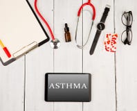 Стетоскоп, доска сзажимом для бумаги, smartphone с текстом & x22; ASTHMA& x22; , стекла, вахта и пилюльки стоковое изображение Стетоскоп, доска сзажимом для бумаги, smartphone с текстом & x22; ASTHMA& x22; , стекла, вахта и пилюльки стоковое изображение