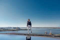 Стильное положение девушки на горе, голубое небо отразило в воде стоковое фото Стильное положение девушки на горе, голубое небо отразило в воде стоковое фото